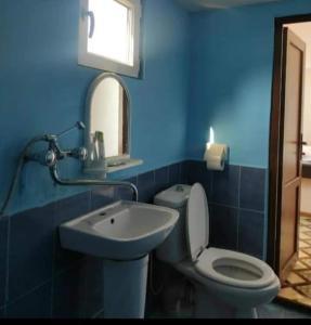 a blue bathroom with a toilet and a sink at MG Guest House in Ijevan