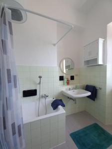 La salle de bains blanche est pourvue d'un lavabo et d'une douche. dans l'établissement Casa MAX, à Onno