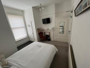 a white room with a bed and a desk at Hotel 50 in Bournemouth