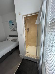 a small bathroom with a shower and a bed at Hotel 50 in Bournemouth