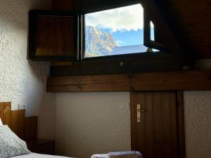 vistas a la montaña desde la ventana del dormitorio en Val di Sole Apartment, en Monclassico