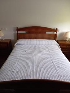 una camera con letto e testata in legno di VT RURALRIA a Portomarin