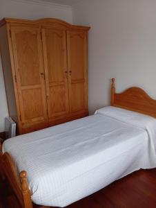 una camera con 2 letti e armadi in legno di VT RURALRIA a Portomarin