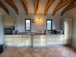 a large kitchen with white cabinets and appliances at Das Ferienhaus am Feld in Gelting