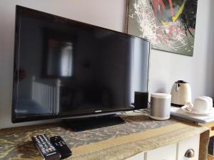 a large flat screen tv sitting on top of a table at Chez Pique-Fesse Chambre d'hote in Saint-Martin-lʼArs
