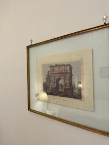 a framed picture of a building on a wall at B&B La Meta in Benevento