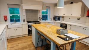 een keuken met witte kasten en een houten aanrecht bij Dale House in Buxton