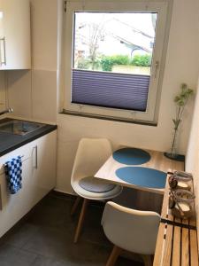 a kitchen with a table and chairs and a window at Muuske in Emden