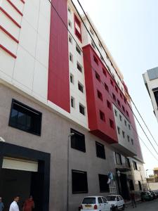 HOTEL SOLTANE في Husseïn Dey: مبنى احمر وبيض على جانب شارع