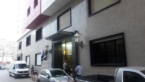 HOTEL SOLTANE في Husseïn Dey: مجموعة من الناس تقف خارج المبنى