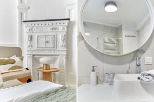a bathroom with a mirror and a bed and a sink at Residence Le Marais by Studio prestige in Paris