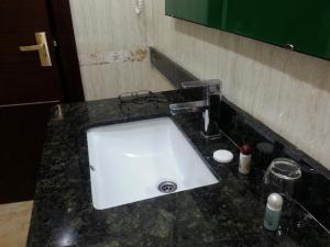 HOTEL SOLTANE في Husseïn Dey: منضدة الحمام مع حوض أبيض ومرآة