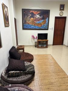 a living room with a couch and a tv at Nua House in Ubud