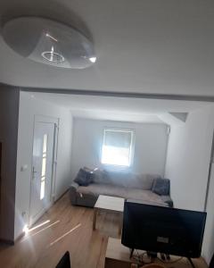 uma sala de estar com um sofá e uma janela em Hiša Palček em Brezice