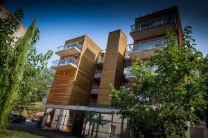 un immeuble avec 2 balcons dans une rue dans l'établissement La Résidence du Spa et la Résidence des Thermes, à Meyras