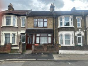 una casa de ladrillo con una puerta roja en una calle en London Holiday Home, en Londres