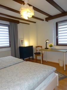een slaapkamer met een bed, een bureau en ramen bij Eifelheimat-Lorbach in Schleiden-Herhahn in Schleiden