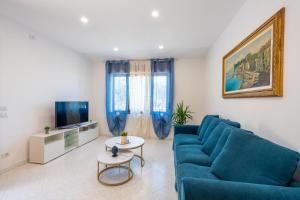 een woonkamer met een blauwe bank en een tv bij Il Tiglio-Holiday Home in Massa Lubrense
