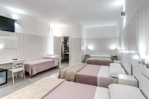 a hotel room with two beds and a desk at AltaDomus Roma in Rome