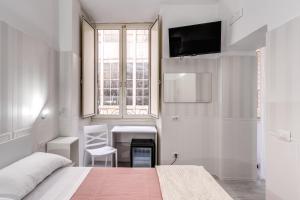 a bedroom with a bed and a desk and a window at AltaDomus Roma in Rome