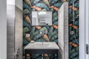 a bathroom with a sink and a leafy wallpaper at AltaDomus Roma in Rome +30 photos