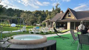 een achtertuin met een speeltuin met stoelen en een schommel bij Dialex Doftana in Teşila