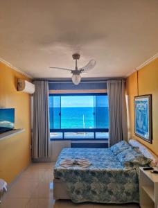 a bedroom with a bed and a view of the ocean at Farol Barra Flat 202 in Salvador