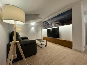 a living room with a couch and a flat screen tv at Aldeas de Ezcaray in Ezcaray