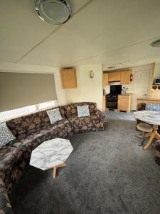 a living room with a couch and a kitchen at Summer Breeze - Family Holiday home in Camber Sands in Camber