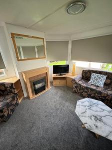 a living room with a couch and a fireplace at Summer Breeze - Family Holiday home in Camber Sands in Camber