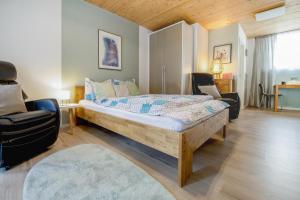 a bedroom with a large bed and two chairs at Erfblick-Apartments in Eichenbühl