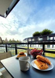 einen Tisch mit Tellern und einer Tasse Kaffee in der Unterkunft Apartament Gwiazda Jantaru by TriApart in Jantar