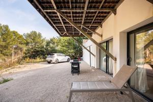 a patio with a chair and a car parked in a driveway at Entre Aix et Marseille in Rognac