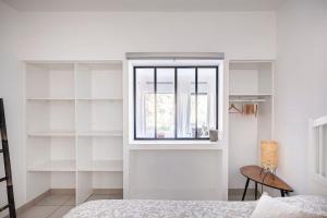 a bedroom with white shelves and a window at Entre Aix et Marseille in Rognac