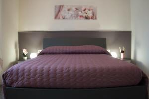 a bed with a purple comforter in a bedroom at Casa Vacanze Podere San Giusto Volterra in Volterra +70 photos