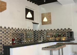a bar with a counter with glasses on the wall at Posada de Palacio in Sanlúcar de Barrameda