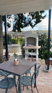 a table and chairs on a patio with a grill at Casa Vacanze Podere San Giusto Volterra in Volterra
