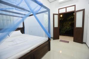 a bed with a blue canopy in a room at Surfside Retreat Weligama in Weligama
