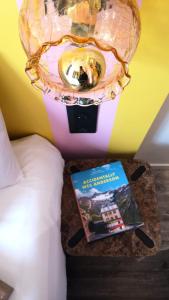 a book on a table next to a bed with a lamp at DEMAIN Hôtel & Conciergerie in Nantes