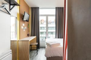 a hotel room with a bed and a window at DEMAIN Hôtel & Conciergerie in Nantes