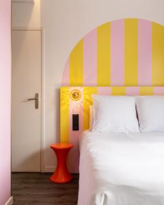 a bedroom with a bed with a colorful headboard at DEMAIN Hôtel & Conciergerie in Nantes