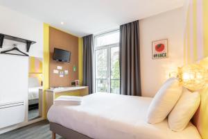 a hotel room with a bed and a window at DEMAIN Hôtel in Nantes