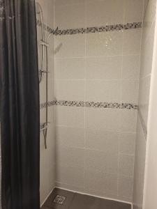 y baño con ducha con cortina negra. en Hudace, en Saint-Laurent-du-Maroni