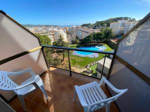 un balcón con 2 sillas y una piscina en Hotel Samba, en Lloret de Mar