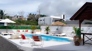 eine Terrasse mit Stühlen und einem Pool in der Unterkunft Villa Paille en Queue in Flic-en-Flac