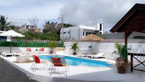 a patio with chairs and a swimming pool at Villa Paille en Queue in Flic-en-Flac