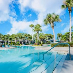 a swimming pool with palm trees in the background at Urban Oasis Getaway in Jacksonville