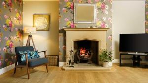 a living room with a fireplace and a tv at Roslyn in Bakewell