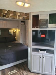 a bedroom with a bed and a tv in a room at Harrison Rv Sanctuary, Pool, Hot tub, 2 Bedrooms in Harrison Hot Springs
