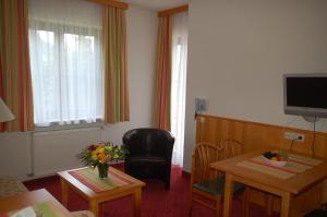 ein Hotelzimmer mit einem Tisch, einem Stuhl, einem Tisch und einem Tisch. in der Unterkunft Hotel Rauscher und Paracelsus in Bad Hofgastein